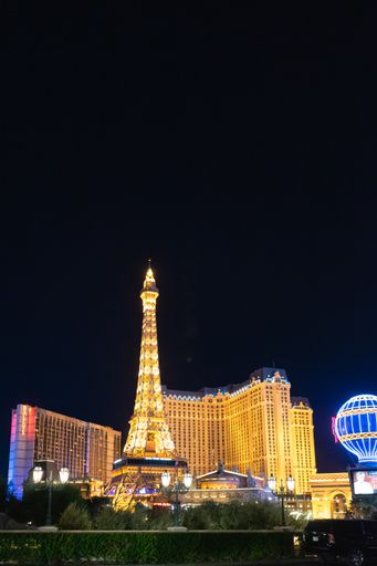 A vertical night shot of the Eiffel Tower in front of the Paris Hotel and Casino in Las Vegas
