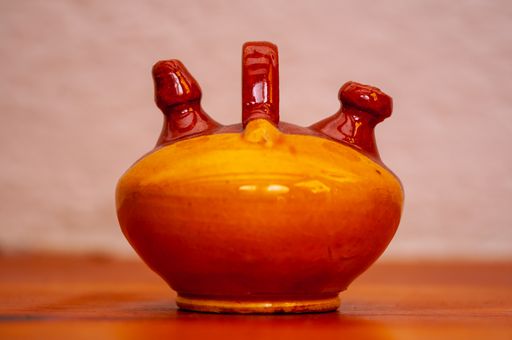 Selective focus of Small clay jug decoration in a wood table