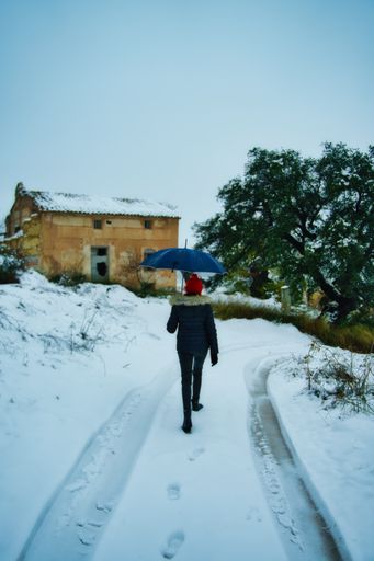 A beautiful shot of a woman walking on a road during winter
