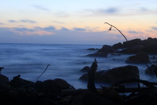 A long exposure shot of the sea at purple sunset