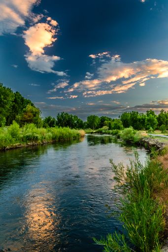 A vertical shot of a cloudy blue sky over the Jordan River in Utah