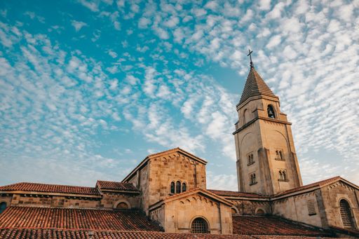 A low angle shot of a San Pedro church against a cloudy sky in Gijon, Asturias, Spain