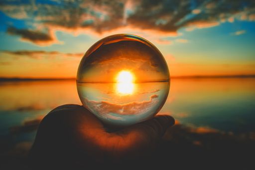 A creative crystal lens ball photography of the sunset with clouds blurred in the background