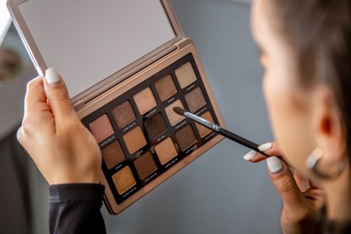 A closeup shot of a young caucasian female doing makeup