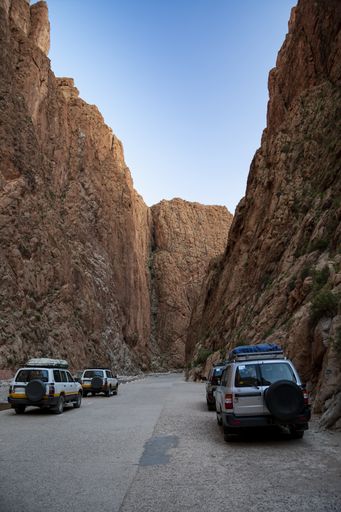 A vertical shot of cars at Todra Gorge under the sunlight and a blue sky in Morocco