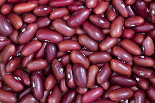 A closeup of raw red beans on the table under the lights - healthy food concept