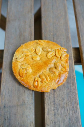 A vertical high angle shot of fresh delicious golden peanut cookie placed on wooden planks