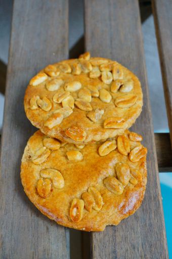 A vertical high angle shot of fresh delicious golden peanut cookies placed on wooden planks