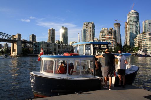 The people by a ship against skyscrapers in Vancouver, British Columbia, Canada