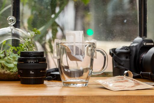 A coffee cup next to photo equipment