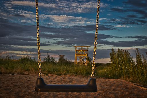 A beautiful shot of a swing in the playground on a cloudy day