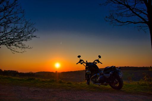 The mesmerizing view of the motorbike in the field during sunset