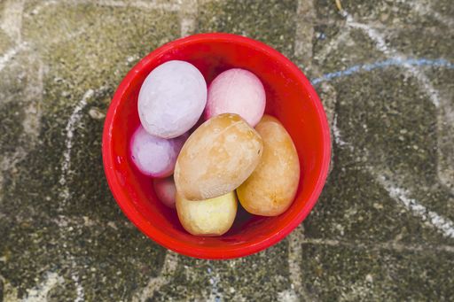 The colorful Easter eggs in a red basket on the ground - perfect for background