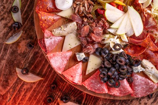 An overhead shot of a variety of meat assortment on a wooden surface