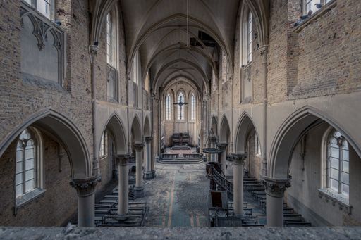 Photograph of an old abandoned church in Belgium. The light shines beautifully through the old windows.