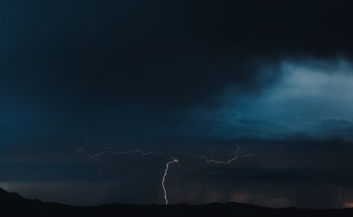 The breathtaking shot of lightning on a navy blue sky