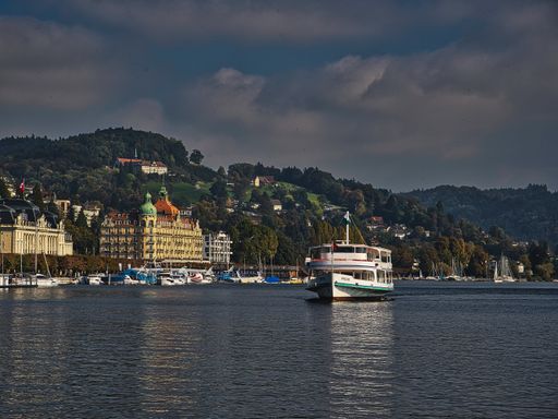 A landscape of ships on Lake Lucerne surrounded by buildings and hills in Switzerland