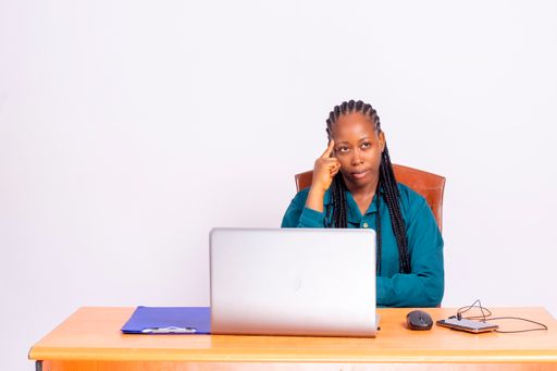 The young African woman sitting at the desk, thinking.
