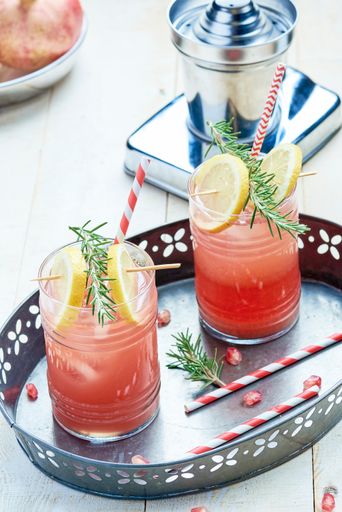 A vertical shot of 2 cups of juice with lemons on a table