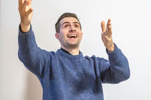 A closeup of the man in a blue sweater isolated on white background.
