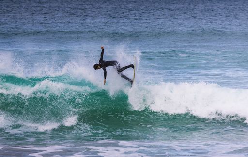A closeup shot of a surfer on the waves of a sea during the day