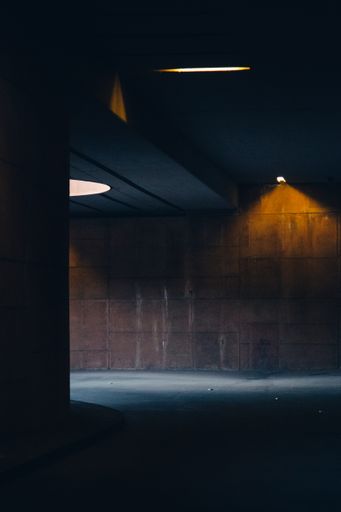 A vertical shot of a dark tunnel with a little light sources