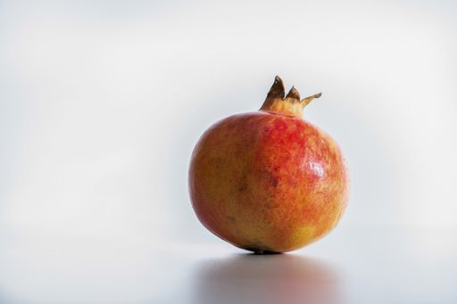 Opened red juicy pomegranate on white background