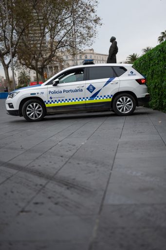 A vertical shot of a port police car with a policeman sitting inside