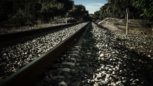 A long shot of railroad tracks and ballast lined with trees