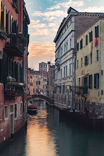 A vertical shot of a channel surrounded by buildings of Venice in Italy at sunset