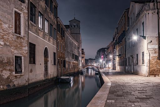 A scenery of a channel surrounded by buildings of Venice in Italy at sunset