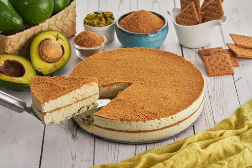 A closeup shot of slicing a piece of cake, avocados, and other ingredients