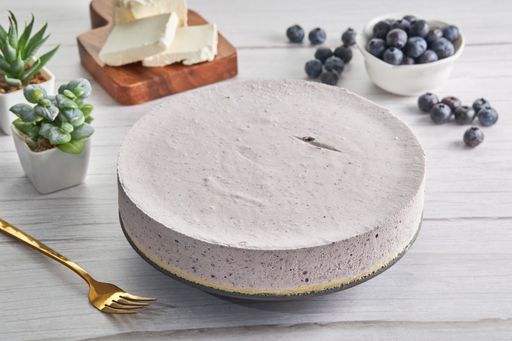A closeup shot of a blueberry cream cake, berries and other ingredients