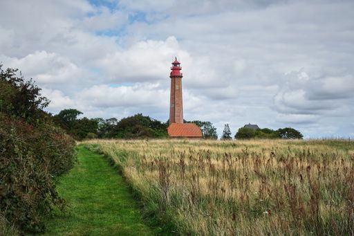 The Flugge lighthouse at the Fehmarn island against a blue cloudy sky on a gloomy day