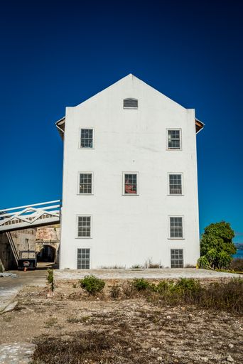 A vertical shot of a white building, the exterior design and windows with clear sky