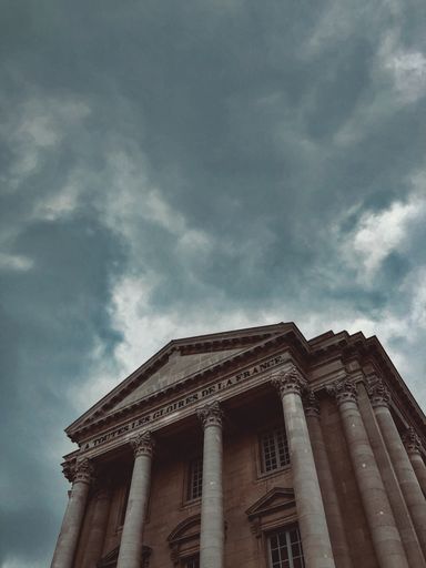 A low angle shot of a modern building under the cloudy skies
