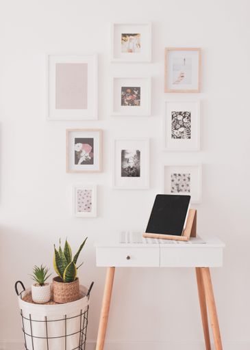 A beautiful vertical shot of a table with a tablet on it and with the background of decorated wall