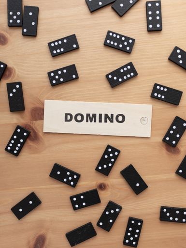 A beautiful high angle vertical shot of the Domino sign and many dominoes mixed placed on a table