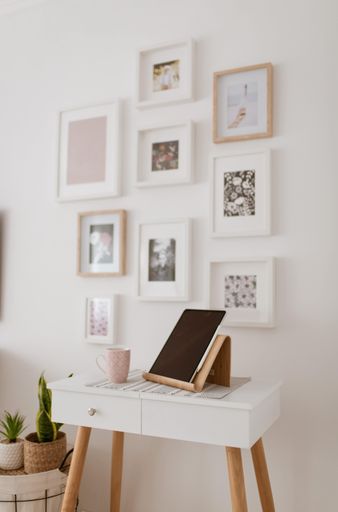 A beautiful vertical shot of a table with a tablet on it and with the background of decorated wall