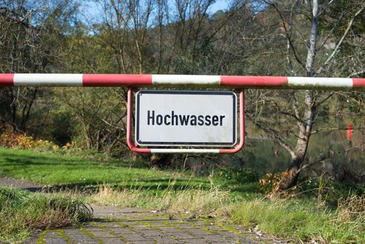 High water sign in german language, next to the river Moselle in Trier, warning for flood, climate change, enviromental issue
