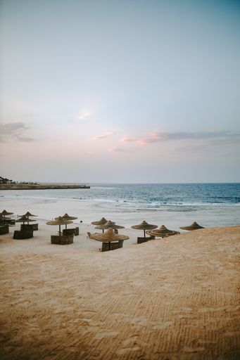 A vertical shot of the Red sea at the Marsa Alam beach with sunbeds at sunset in Egypt