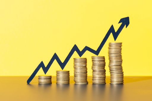 Stacks of coins with rising arrow indicating wealth, business growth