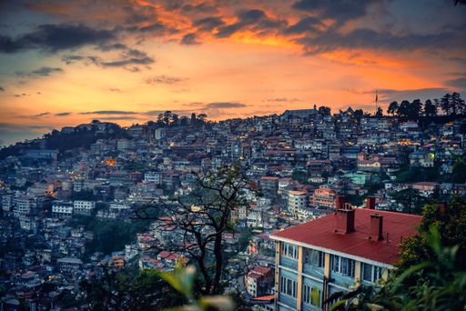 A beautiful sunset over a mountain slope engulfed with buildings in Shimla, North India