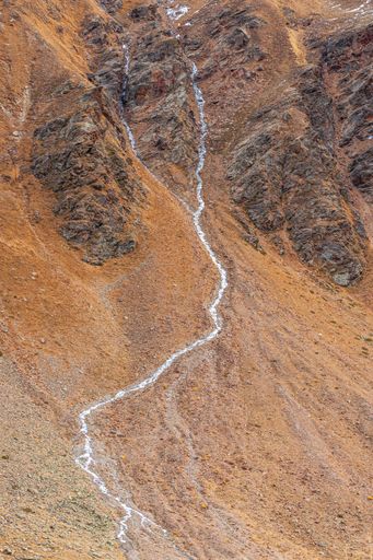 A vertical aerial view of rocky landscapes with orange grass