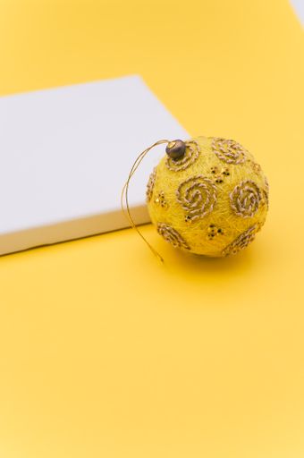 Elegant yellow silver Christmas decorations and painting canvas with sapce for text on a yellow tabletop surface