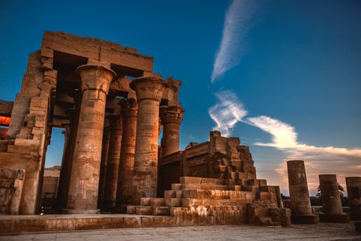 A minimizing vertical view of the Temple of Kom Ombo in Aswan, Egypt against a blue sky