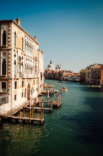 A vertical shot of a channel and buildings of Venice in Italy on the shore