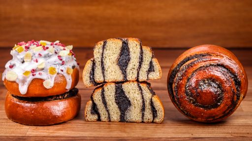 A close-up shot of delicious homemade Russian Kulich (Easter Bread) and poppy seed bun on a table