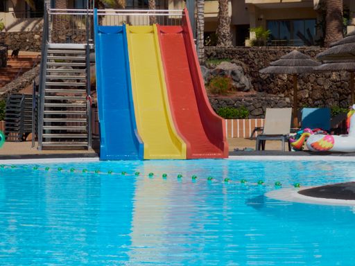 A bright summer day at a water park with colorful slides in it