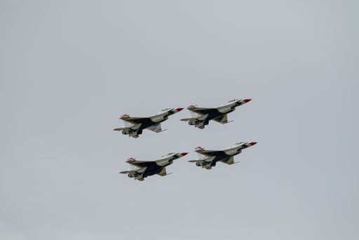 A group of flying aircraft against a gloomy sky during an airshow